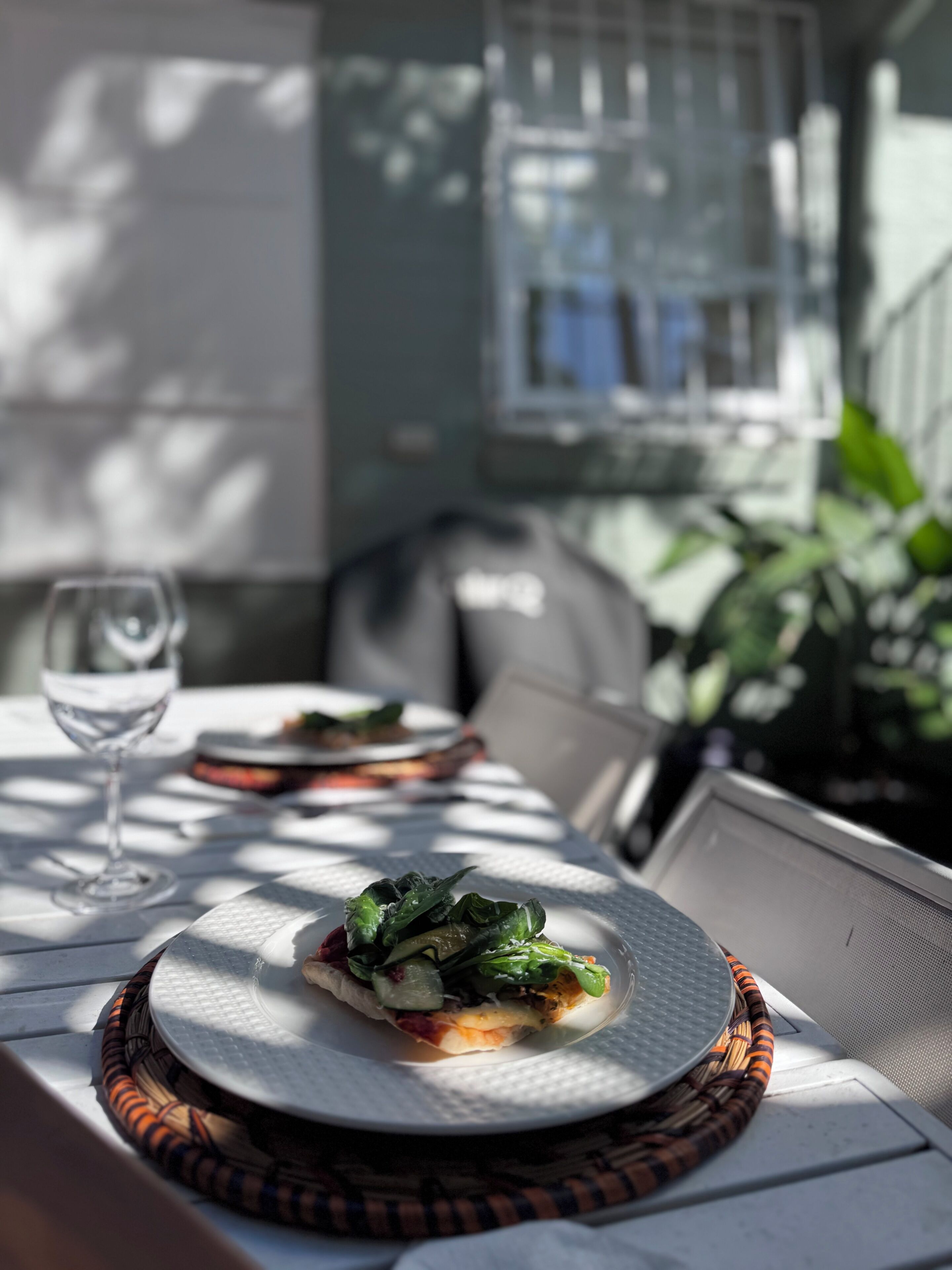 A table with a plate of food, a glass of water, and a chair.