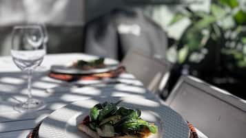 A table with a plate of food, a glass of water, and a chair.