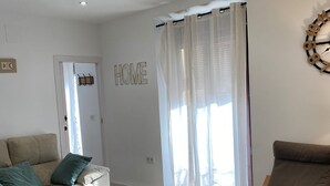 Una sala de estar con sofá, sillón, mesa de centro y un letrero que dice 'HOME'.