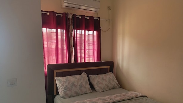 Un lit simple avec une tête de lit, deux oreillers et une couvre-lit.