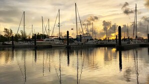 A marina with multiple boats docked at the pier, reflecting the sunset on the water. - Three Condos w/ Entertainment, Private Parking & Beach Nearby - Great for Groups (Key West)