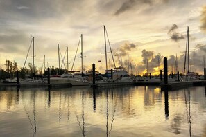A marina with multiple boats docked at the pier, reflecting the sunset on the water. - Charming Condo w/ Entertainment & Private Parking - Great In-Town Location (Key West)