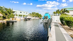 A marina with boats docked, a water treatment facility, and buildings with balconies. - Waterfront home with amazing views, boat dock, screened porch & water sport gear (Key Largo)