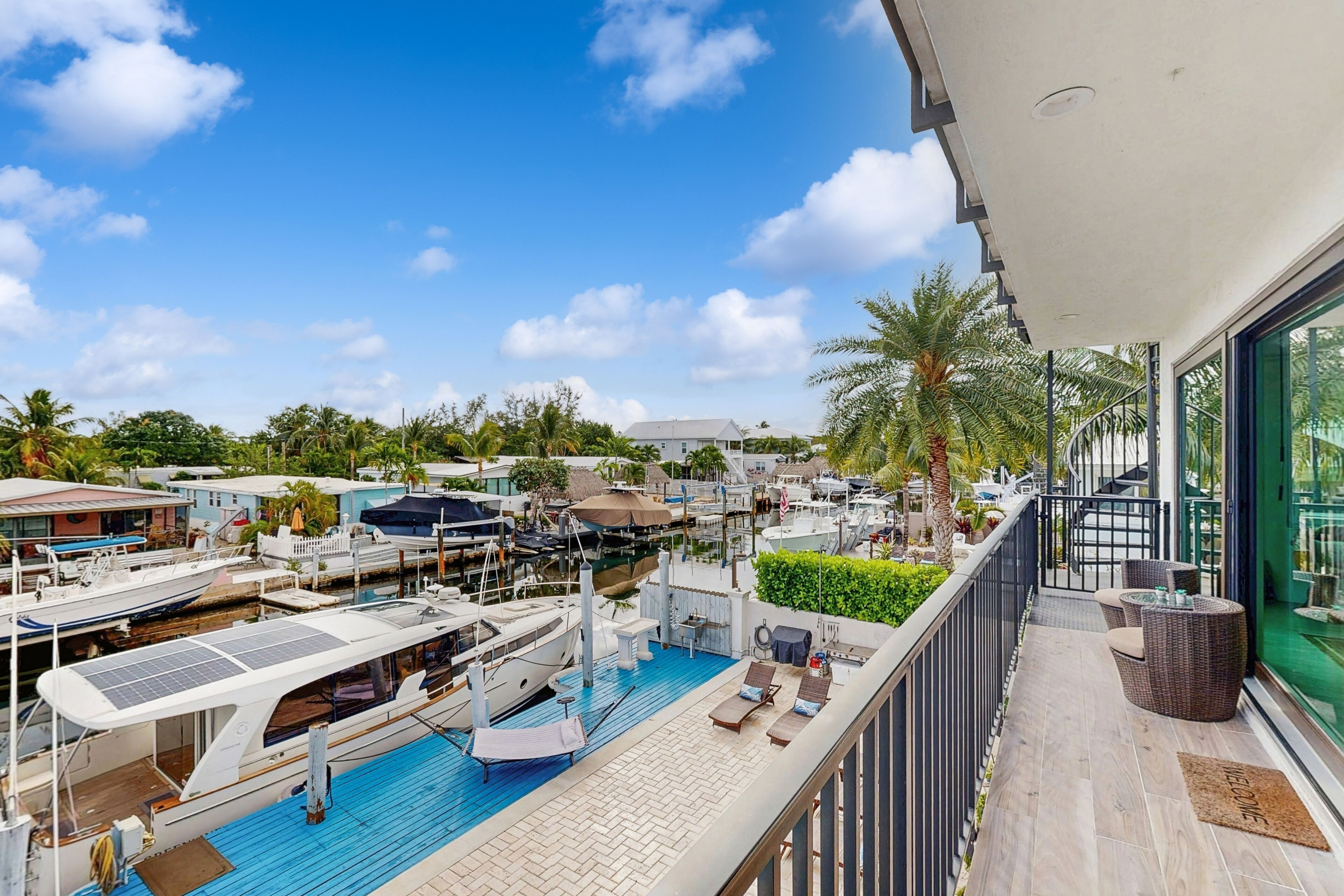 Une piscine sur le toit, dotée de chaises longues et offrant une vue sur les bateaux et les yachts amarrés dans une marina.