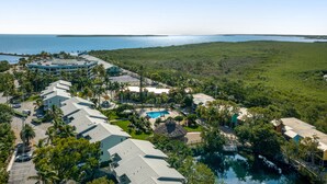 A resort with multiple buildings, a swimming pool, and a view of the ocean. - Tropical condo with 2 pools, private beach area, swimming lagoon, tennis & AC (Key Largo)