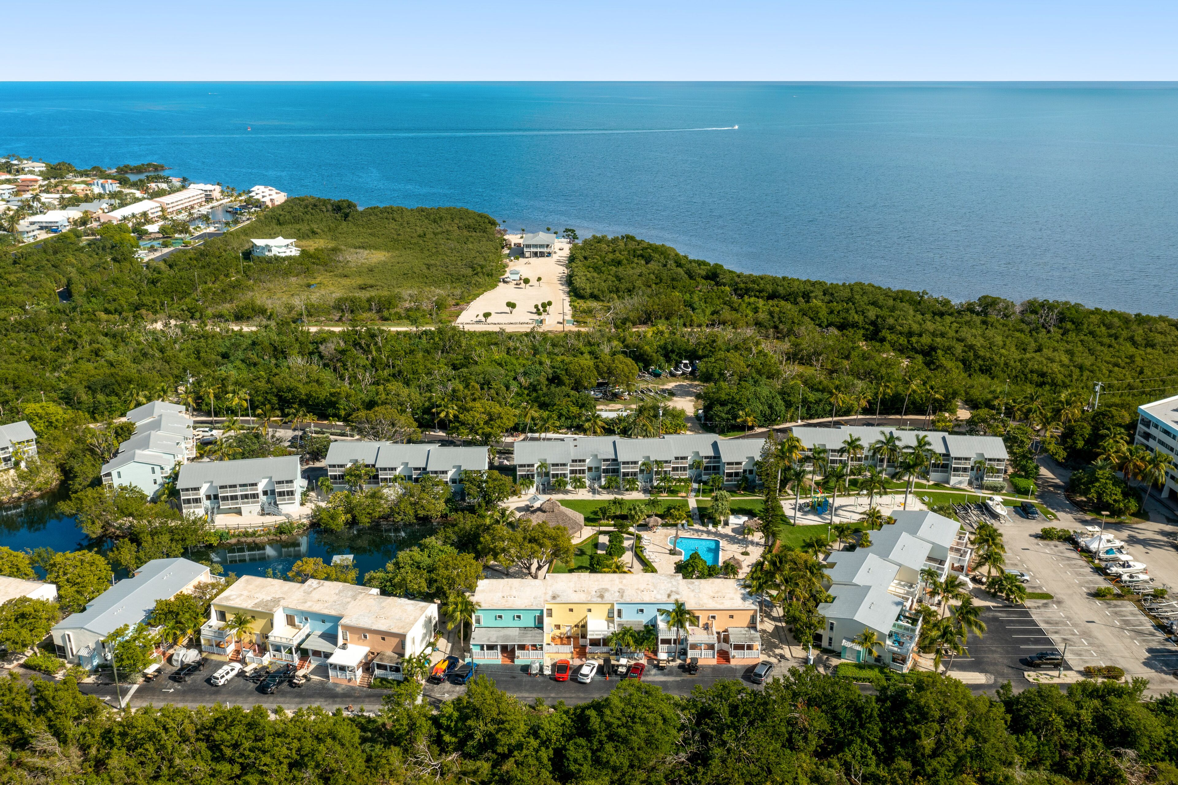 Vista aérea de um resort com vários edifícios, piscina e área de estacionamento.