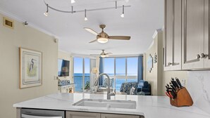 Una cucina con un'isola grande, un ventilatore a soffitto e vista all'esterno.
