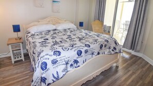 Una camera da letto con un letto, un comodino, una sedia e vista sull'esterno.