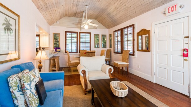 A spacious living area with a high ceiling, wooden beams, and a white door marked "EXIT". - Spacious Key West Conch Cottage with WiFi & Private Hot Tub - Dogs OK (Key West)