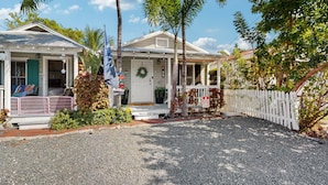 A two-story house with a porch, a front door, and a small garden area. - Pool, Pet-friendly, Bicycles and 5 min walk to Beach (Key West)