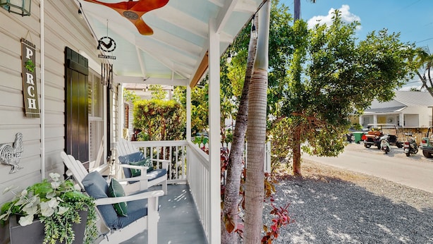 A porch with white railings, a ceiling fan, and outdoor seating. - Pool, Pet-friendly, Bicycles and 5 min walk to Beach (Key West)