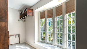 A room with large windows, a wooden door, and a ceiling-mounted light fixture. - The Southernmost Comfort House — Private Pool + Waterfall | 5BR Truman Annex Estate | 28-Day Stay (Key West)