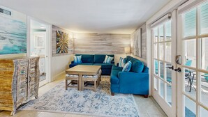 Een gezellige woonkamer met een blauwe bank, een houten salontafel en een decor kast.