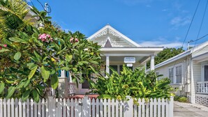 A white building with a sign reading "Center Court" and a white picket fence in front.