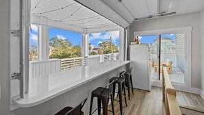 Una cucina moderna con un'isola grande, sgabelli da bar e ampie finestre che si affacciano sul quartiere.
