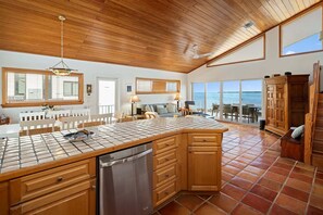 A spacious kitchen with wooden cabinets, a tiled backsplash, and a large island. - Oceanfront home with a pool, dock, grill, scenic balconies, games, W/D, & AC (Tavernier)