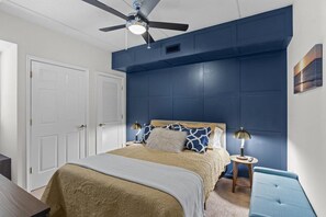 A bedroom with a bed, two bedside tables, a ceiling fan, and a wall-mounted artwork. - Pups and Pints - Water View - We Love Dogs (Wilmington)