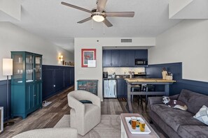 Ein modernes Wohnzimmer mit Sofa, Essbereich und Küche.