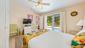A hotel room with a bed, a television, a desk, and a view of the outdoors. - Old Town Key West classic with private saltwater pool & enclosed patio- by shops (Key West)