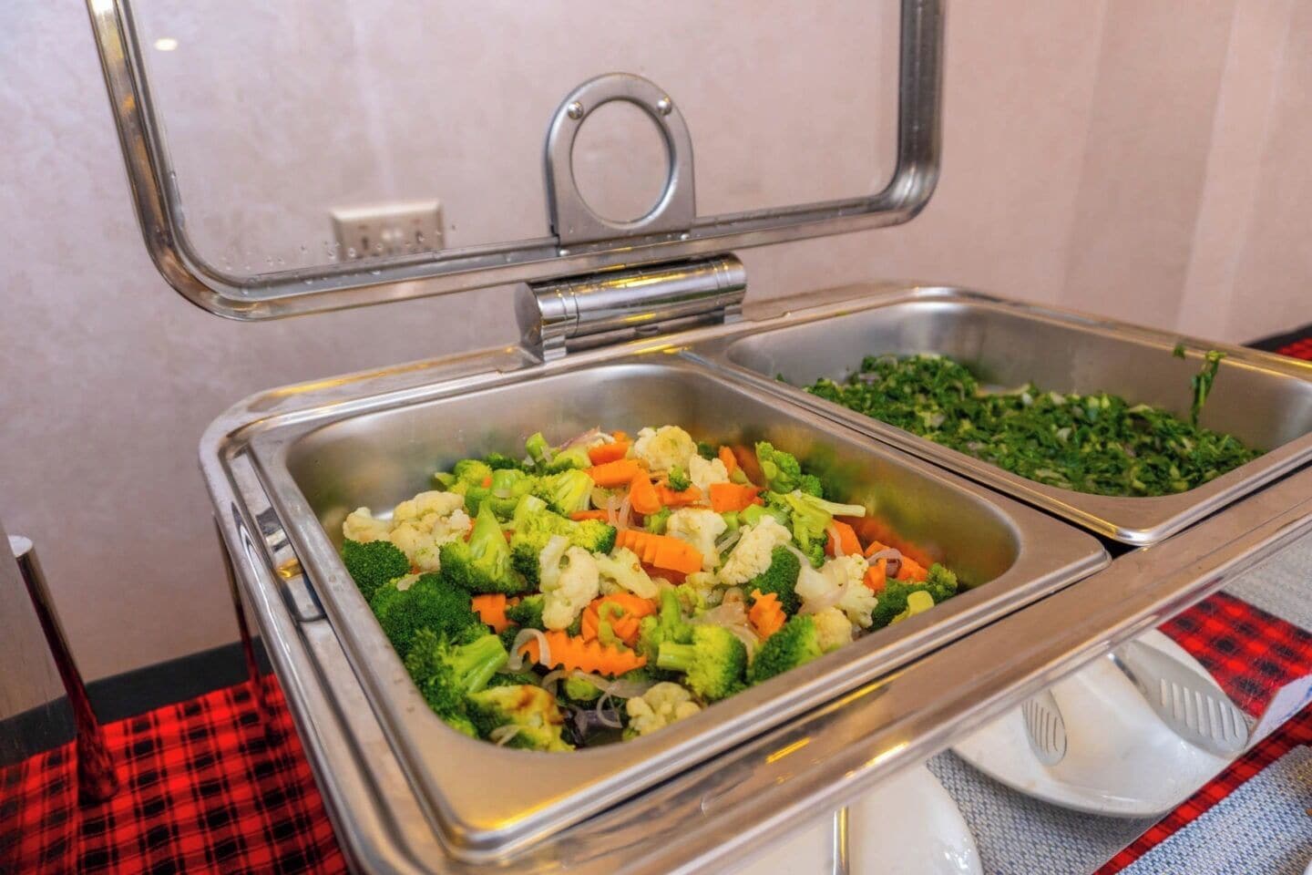 A buffet with various vegetables like broccoli, carrots, and cauliflower.