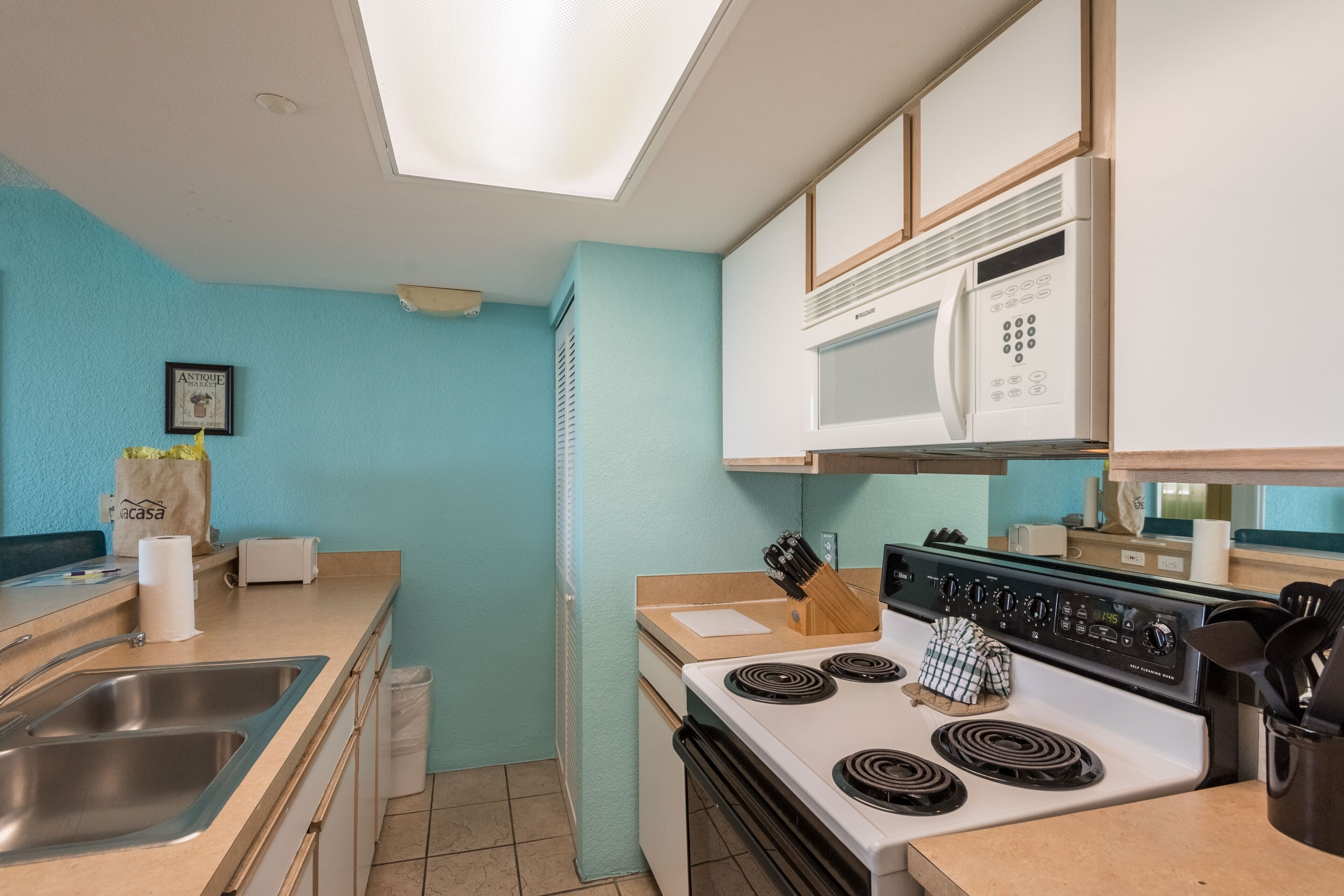 A kitchen with a microwave, stove, and sink.