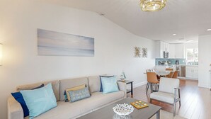 Een moderne woonkamer met een bank, salontafel en uitzicht op de keuken.