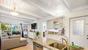 A kitchen with granite countertops, stainless steel sink, and a dishwasher. - Waterfront home with gorgeous patio, WiFi, gas grill, & great location (Key Colony Beach)