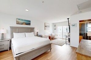 A spacious bedroom with a large bed, bedside tables, a desk, and a chair. - Condo in Marathon with waterfront pool, patio, kayak & sundeck (Marathon)
