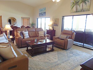 A living room with a sofa, armchairs, a coffee table, and a large window. - Waterfront home with ocean views, dock, & private outdoor pool (Marathon)