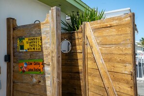 A wooden gate with a sign listing prices for showers, watching, photos, and personal attention. - Waterfront Home w/ Private Dock, Outdoor Shower & Home Office - Dog-Friendly (Marathon)