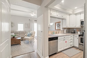 A modern kitchen with white cabinetry, a dishwasher, a microwave, and a toaster. - Cozy home with outdoor shared pool, central AC, internet (Marathon)