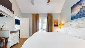 Ein Schlafzimmer mit einem großen Bett, einem Schminktisch, einem Spiegel und einem Bild an der Wand.
