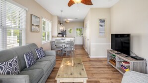 A modern living room with a grey sofa, wooden coffee table, and a ceiling fan. - Waterfront retreat with balcony views, kayak, SUP, central AC & washer/dryer (Duck Key)