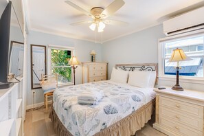 A bedroom with a bed, a dresser, a nightstand, a chair, a ceiling fan, and a window with an air conditioning unit. - Dog-Friendly Home on the Water w/ Dock, Boat Access, Private Pool, & Free WiFi (Marathon)