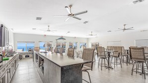 A spacious kitchen with a central island, multiple ceiling fans, and a view of the ocean through large windows. - Snowbird-friendly condo in oceanfront complex with heated pool, BBQ, W/D, AC (Marathon)
