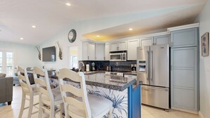 A modern kitchen with white cabinetry, a granite countertop, and stainless steel appliances. - Private pool, boat dock, water view, canal front, fully equipped kitchen (Marathon)