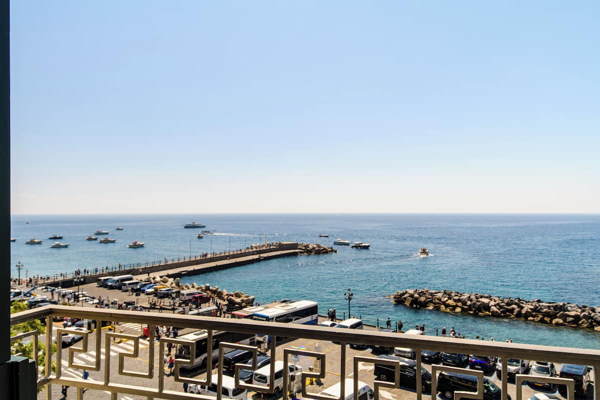 A coastal view with a pier, boats, and a clear sky.