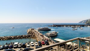 A coastal view with a marina, parked cars, and boats. - AMALFI GALLERY (Amalfi)