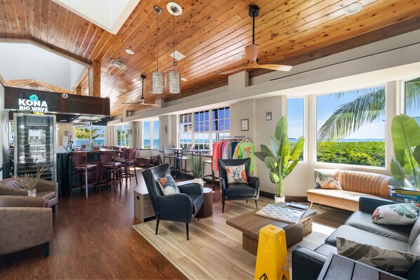 A spacious hotel lobby with a wooden ceiling, a bar area, seating arrangements, and large windows offering a view of the outdoors. - Breezy condo on the water with pool, hot tub & tennis court (Tavernier)