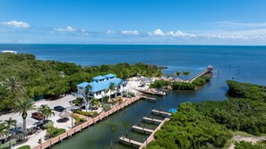 A coastal property with a dock, a pool, and a beach area. - Breezy condo on the water with pool, hot tub & tennis court (Tavernier)