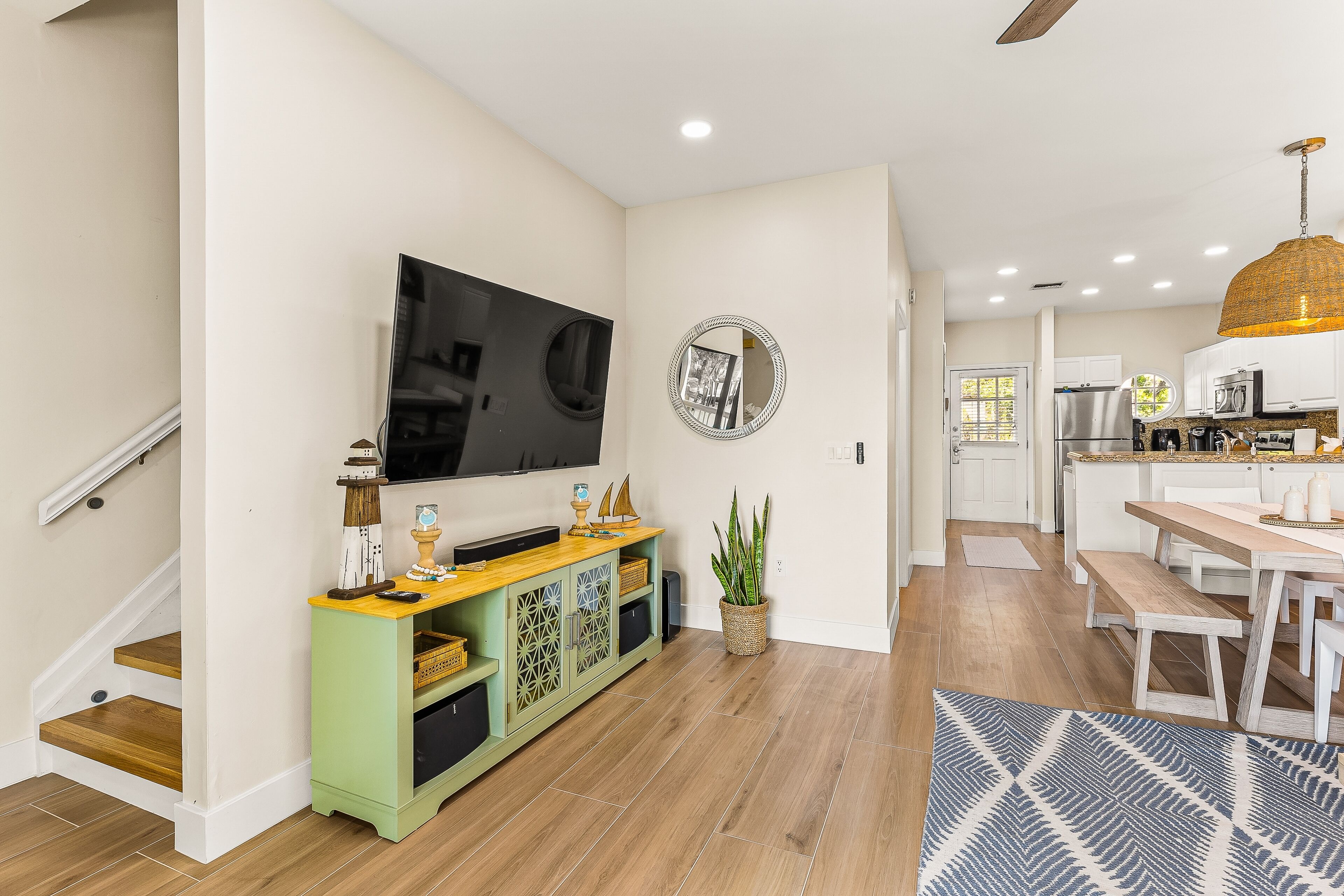 A modern kitchen with white cabinets, a wooden countertop, and a large island.