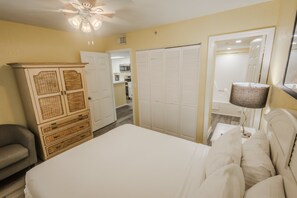 A bedroom with a bed, a wardrobe, a mirror, and a ceiling fan. - Resort suite with pool, hot tub, tennis & full kitchen (Key West)