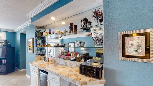 Een keuken met een aanrecht, kastjes en een decoratieve vaas op de plank.