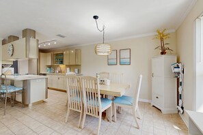 A kitchen with a dining area, a white cabinet, and a ceiling light fixture. - Oceanside condo with heated pool, tennis courts & great location (Marathon)