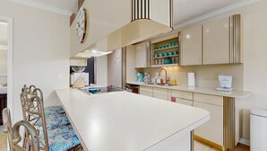 A modern kitchen with a central island, built-in cabinets, and a clock on the wall. - Oceanside condo with heated pool, tennis courts & great location (Marathon)
