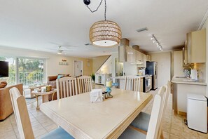 A modern kitchen with a dining area, a TV, and a view of the outdoors. - Oceanside condo with heated pool, tennis courts & great location (Marathon)