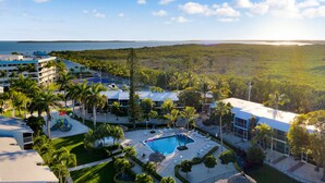 Un complexe hôtelier doté d’une piscine, de palmiers et offrant une vue sur l’océan.