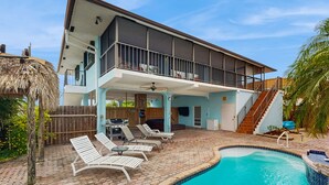Uma casa moderna de dois andares com varanda coberta, piscina e deck de madeira.