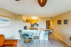 A modern kitchen with a central island, dining area with chairs, and a living room with a sofa. - Coastal retreat with private balcony, pool, & easy beach access (Tavernier)