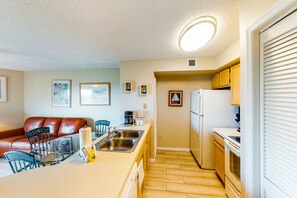 A compact kitchen with a dining area, featuring a coffee maker, a refrigerator, and a sink. - Coastal retreat with private balcony, pool, & easy beach access (Tavernier)